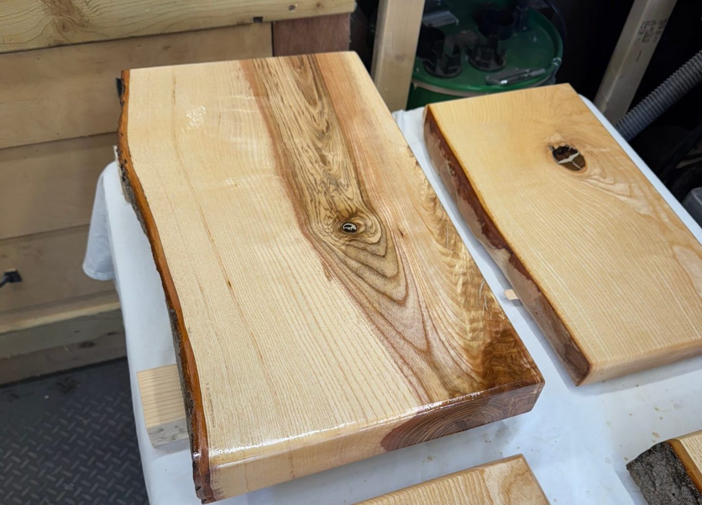 Olive Ash Chopping Board Polished wooden slabs with natural edges on a white surface.